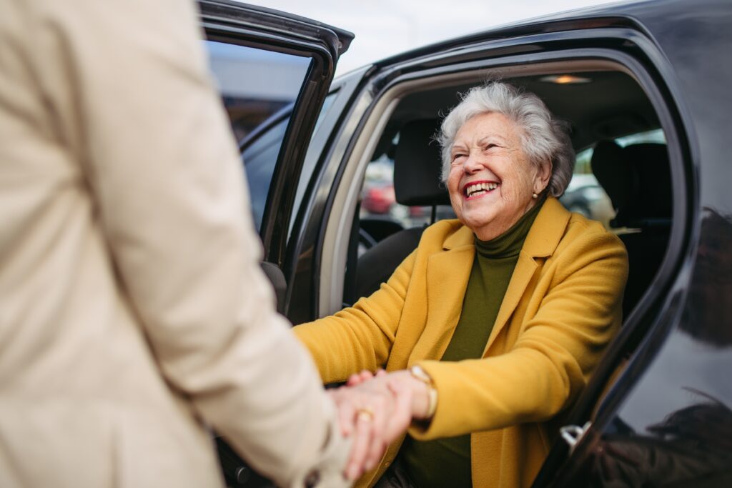 older lady getting assistance while exiting a car